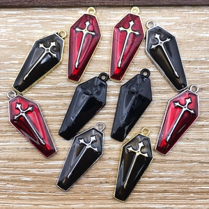 Detailed macro view of gothic coffin cross pendants on a rustic wood background