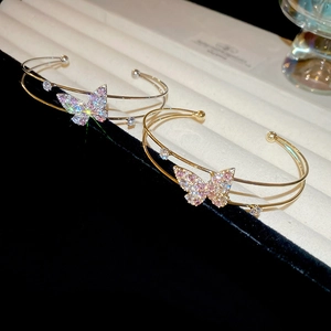 Macro view of double-layer zircon butterfly open bangles in gold and silver finish