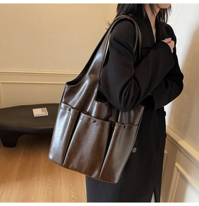 Detail of vintage brown large capacity shoulder bag with external pockets and soft leather