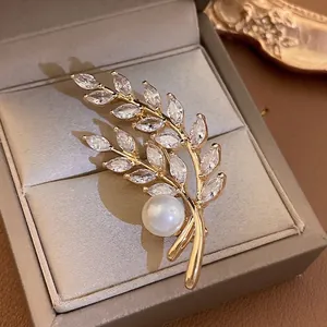 Elegant gold plated wheat brooch with marquise zircons and white pearl on velvet