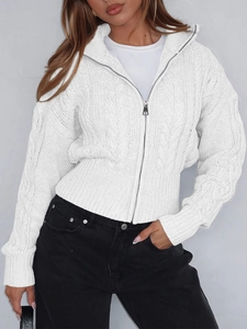 Dettaglio di un cardigan bianco a treccia con cerniera in metallo argentato e trama
