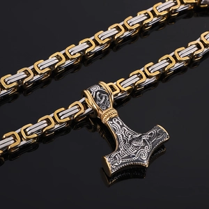 Close-up of dual-tone Viking Mjolnir pendant with intricate Nordic engravings on woven chain