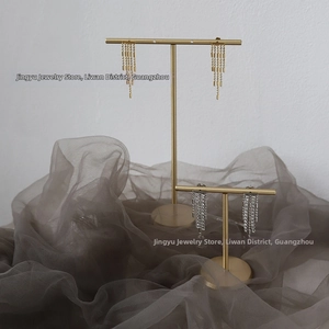 Detail of luxury gold long chain tassels and silver rhinestone fringe earrings on display