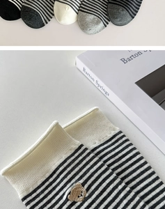 Detail der Bärenstickerei und schwarzen Streifen auf weichen Baumwollsocken