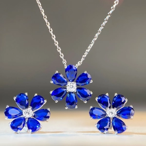 Detailed view of daisy-shaped jewelry set with pear-cut blue gems and silver finish