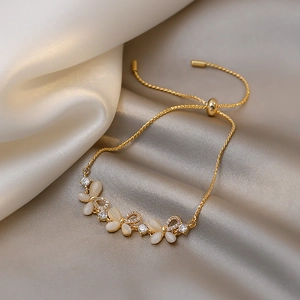 Detail of gold butterfly bracelet with cat's eye stone and adjustable slider clasp
