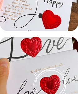 Detail showing white card with faceted 3D red heart decoration and elegant golden text