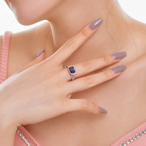 Macro detail of silver S925 ring featuring an oval blue gemstone with a halo of zircons