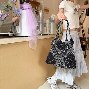 Close-up of black paisley canvas tote bag featuring woven straps and floral patterns