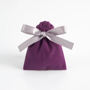 Compact purple velvet drawstring jewelry pouch featuring a shiny silver satin ribbon bow