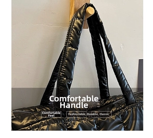 Close-up of comfortable padded handles on a black quilted nylon tote bag for women
