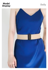 Detail of beige elastic waist belt with black metal buckle on a navy satin dress