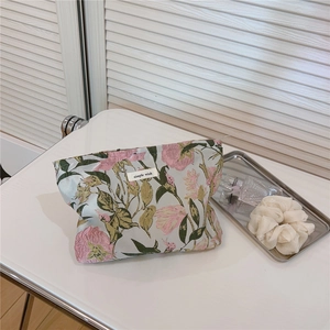 Macro detail of pink floral jacquard fabric and simple wish label on travel cosmetic bag