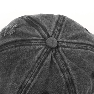 Detail der gewaschenen anthrazitgrauen Baumwoll-Basecap mit abgenutzter Textur und Knopf