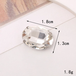 Macro view of 1.8x1.3cm oval glass crystal gem with four metal claws for sewing