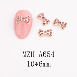 Close-up of 10x6mm pink rhinestone bow nail art charm with golden metal base