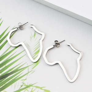 Gros plan de boucles d'oreilles carte d'Afrique en acier inoxydable argenté sur fond blanc