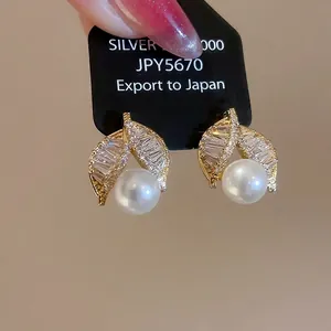 Elegant gold-plated leaf stud earrings with white pearls and sparkling cubic zirconia stones