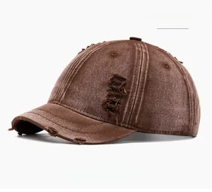 Detail of coffee brown distressed cotton baseball cap with ripped brim and vintage texture