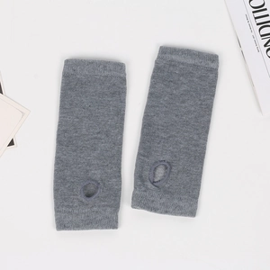 Close-up of grey knitted fingerless arm warmers with thumb holes and ribbed cuffs