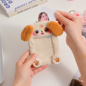Detail showing hand inserting idol photocard into plush dog-shaped card holder