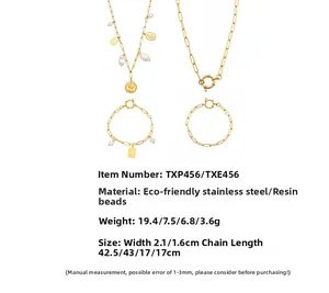 Golden stainless steel jewelry set with coin pendants and paperclip chain details