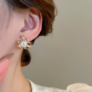 Close-up of pearl and zircon bow earrings shown on model for a vintage French style