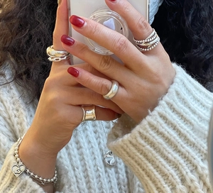 Detail of 925 sterling silver jewelry set featuring vintage rings and heart charm bracelet
