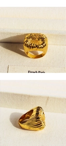 Detail showing the radial brushed texture and golden finish of the wide fashion ring
