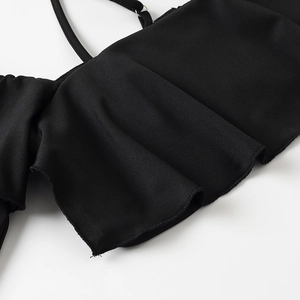 Dettaglio del tessuto in maglia nera con elegante bordo a lattuga e trama a costine