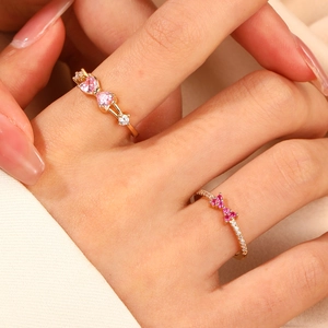 Schicke Goldringe mit rosa Herz-Zirkonia und Schleifendesign an den Fingern