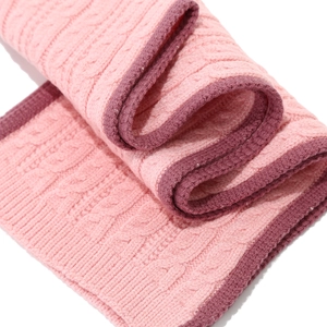Nahaufnahme eines rosa Zopfstrick-Winteralschals mit hochwertiger, dicker Webstruktur
