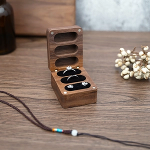 Detailed view of dark walnut jewelry box with three slots and black velvet lining
