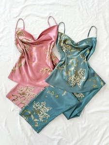 Detail of floral satin pajama set with draped neckline and smooth silk texture