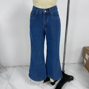 Détail du jean évasé à taille haute en délavage bleu foncé avec texture denim