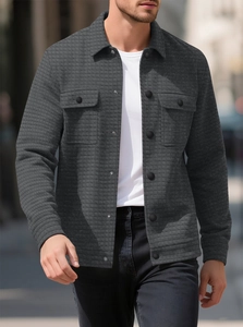 Close-up of men's dark gray jacket with waffle texture fabric and double chest pockets