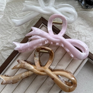 Tre eleganti fermagli per capelli nei colori bianco, rosa e ambra con finitura lucida