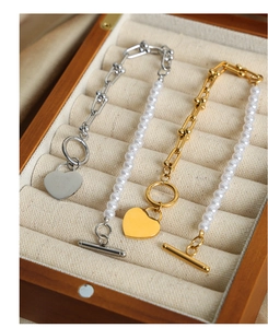 Detailed macro view of heart pendant necklaces with pearls and U-shaped metal link chains