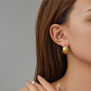 Luxury gold stainless steel earrings with colorful zircon stones on model's ear