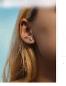 Close-up of S925 silver heart stud earrings with turquoise trim worn on model ear