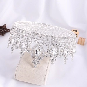 Detailed view of Baroque silver bridal crown with crystals on a beige display stand