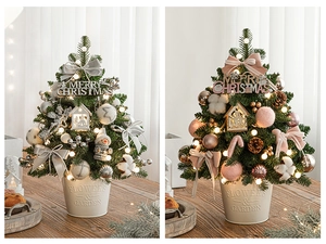 Detailed view of decorated mini Christmas trees in silver and pink themes on a wooden table