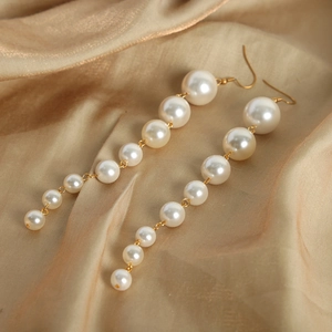 Elegant vintage tassel drop earrings with tiered white pearls and gold metal hooks