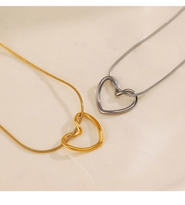 Detail of heart pendants on snake chains in 18K gold and silver finishes