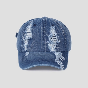 Close-up of distressed vintage denim baseball cap with vertical frayed hole details