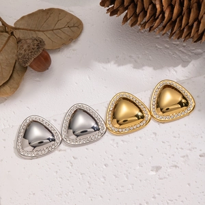 Dettaglio di orecchini a triangolo geometrico con strass scintillanti nei colori oro e argento