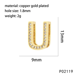 Macro detail of gold plated letter U charm with white zircons and technical dimensions