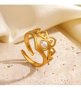 Macro detail of crown ring with pearl inlay, gold finish, and heart cutouts