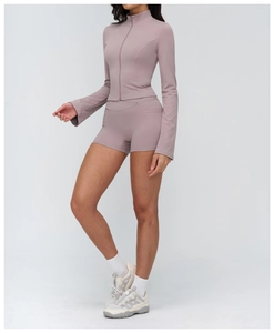 Detail of pink long sleeve yoga top with zipper and high waist sports shorts with side pockets