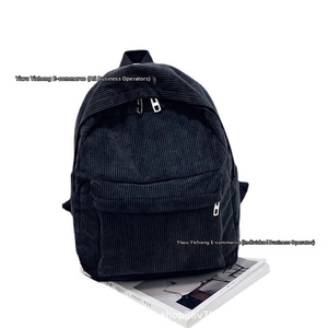 Detailed view of retro corduroy backpack fabric and front zipper pocket texture